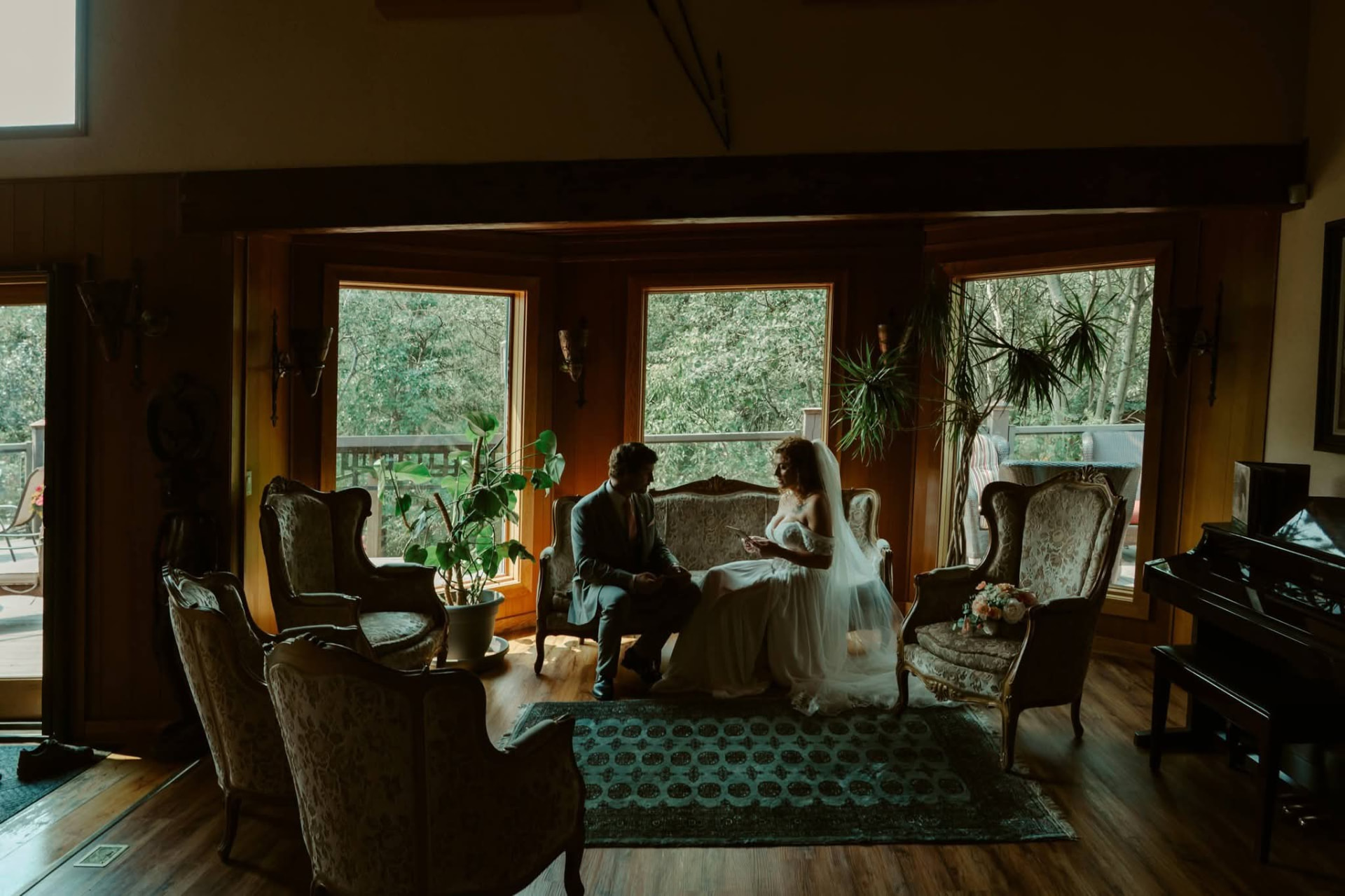 A bride and groom reading vows together in the lodge's sunroom