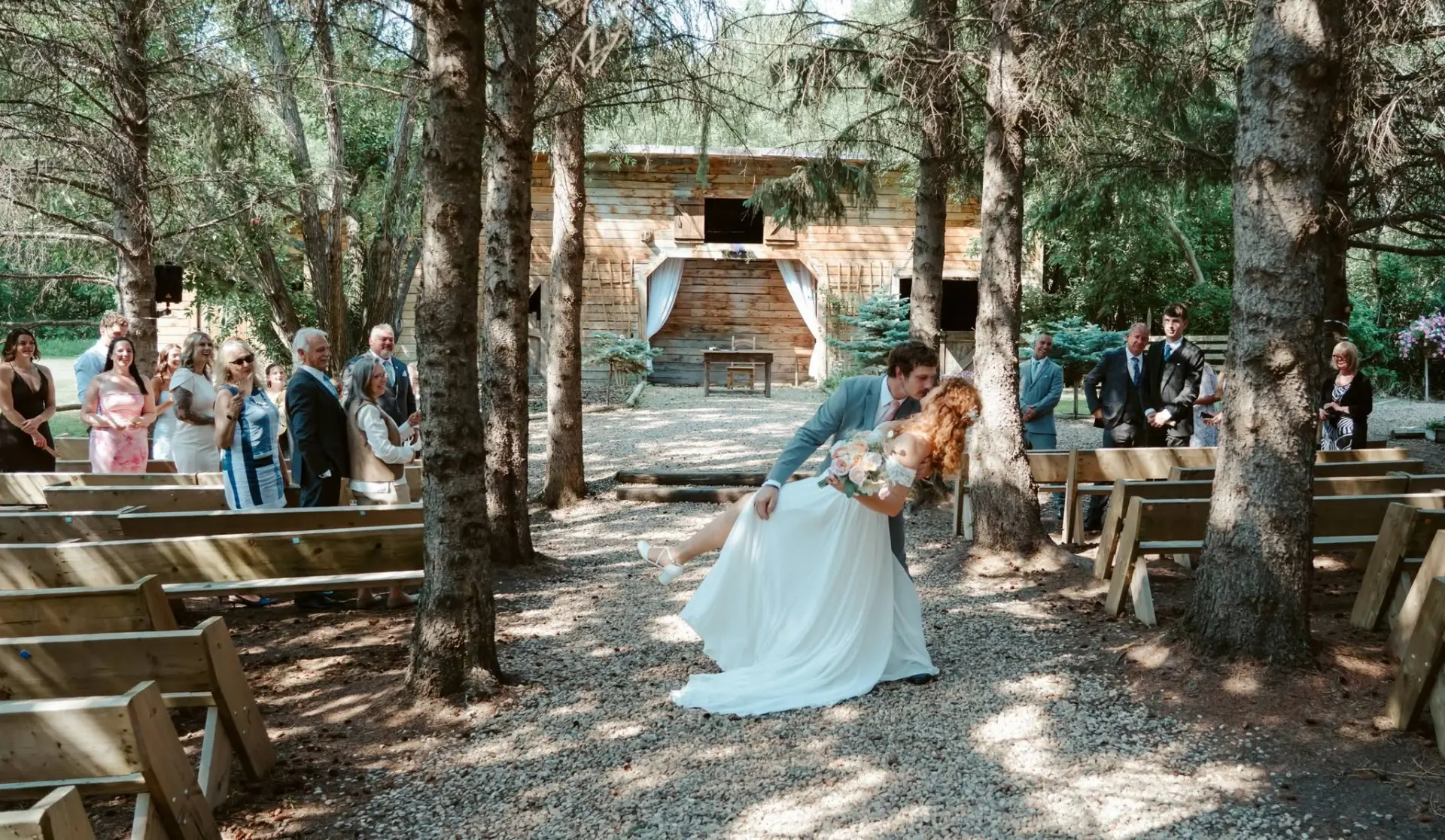 Wedding kiss in the forest ceremony aisle