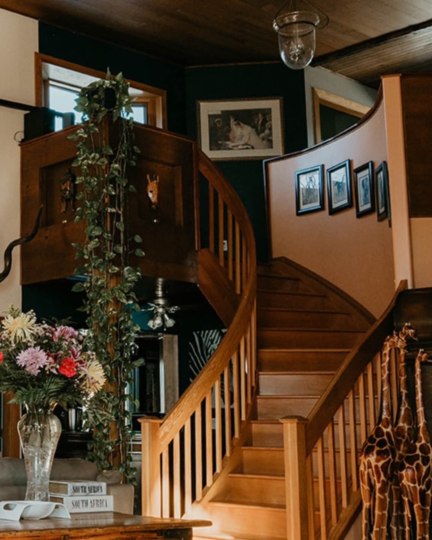 The curved wooden staircase with flowers and South African decor